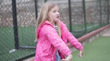 Neşeli bir kız baharda çocuk parkında boş bir salıncak sallıyor. Koronavirüste yürüyorum..