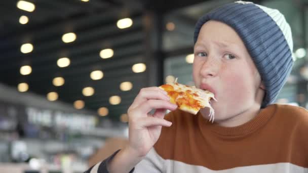 一个饥饿的学童在快餐店里吃比萨饼 — 图库视频影像