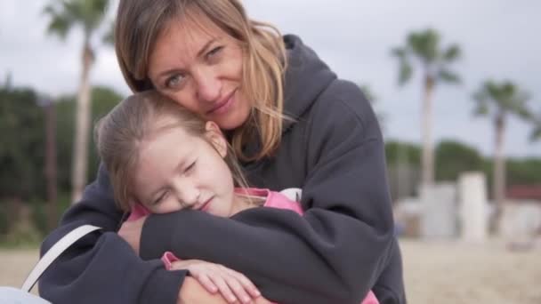 Κορούλα Κάθεται Στην Αγκαλιά Της Μαμάς Την Άνοιξη Στην Παραλία — Αρχείο Βίντεο