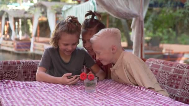 Mutlu Çocuklar Bir Türk Restoranında Masada Oturup Telefonda Oynuyorlar — Stok video