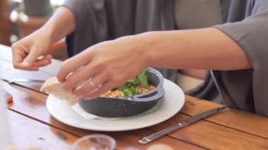 Bir kadın, sabah Türkiye 'de bir restoranda aç bir turistin yakın plan çekimi olan ekmekle sebzeli omletle kahvaltı yapıyor..