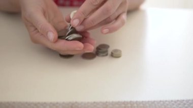 Yakın plan, bir adam masada bozuk para sayıyor..