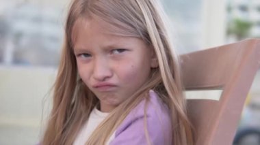 6 yaşında, gücenmiş, sarı saçlı bir kızın yakın çekimi..