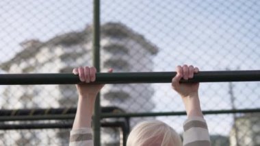 Yakışıklı sarışın bir çocuk sokakta kendini bara çekiyor. Bir öğrenci güç için fiziksel egzersiz yapıyor..