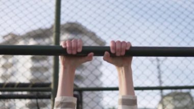 Yakından, yavaş çekimde, sarışın çocuk sokakta barın önüne yanaşıyor. Gençlerin spor anlayışı yazın yürüyüşe çıkmaktır..