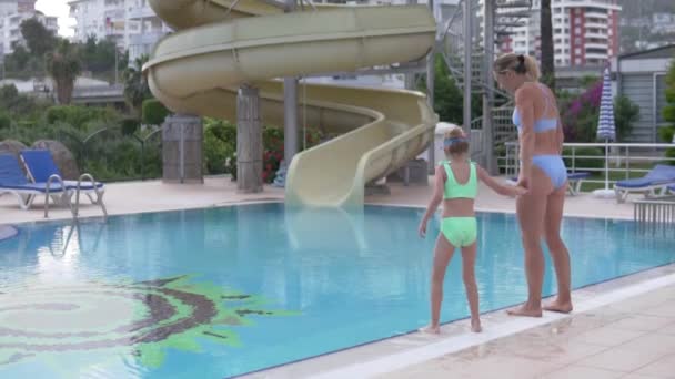 Mãe Filha Saltam Para Piscina Verão Mãos Dadas Visão Traseira — Vídeo de Stock