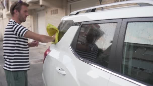 Όμορφος Άνδρας Πλένει Ένα Λευκό Αυτοκίνητο Ένα Κουρέλι Στην Αυλή — Αρχείο Βίντεο