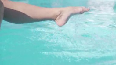 Havuzda su sıçrayan kadın bacakları, parlak ışık, parıltı.