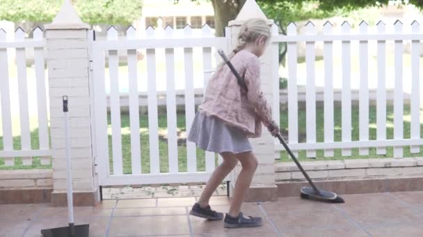 Gadis Kecil Dengan Kain Pel Dan Lap Membersihkan Halaman Rumah — Stok Video