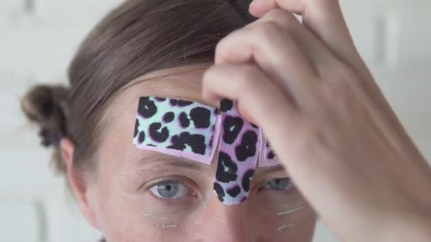 Eine Frau Entfernt Helle Kosmetikbänder Aus Ihrem Gesicht Falten Auf — Stockvideo