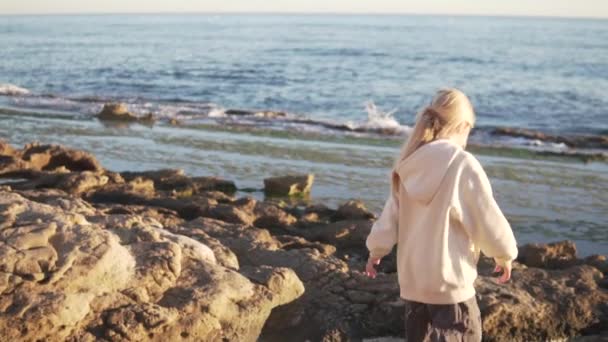Een Meisje Loopt Een Rotsachtig Strand Avond Bij Zonsondergang Spanje — Stockvideo