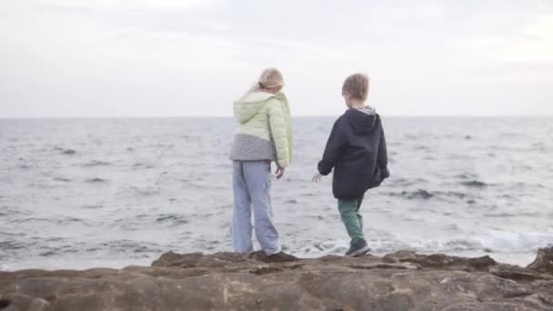 Маленький Хлопчик Дівчинка Гуляє Кам Янистому Пляжі Біля Моря Взимку — стокове відео