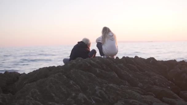 Брат Сестра Сидять Кам Янистому Пляжі Біля Моря Заході Сонця — стокове відео