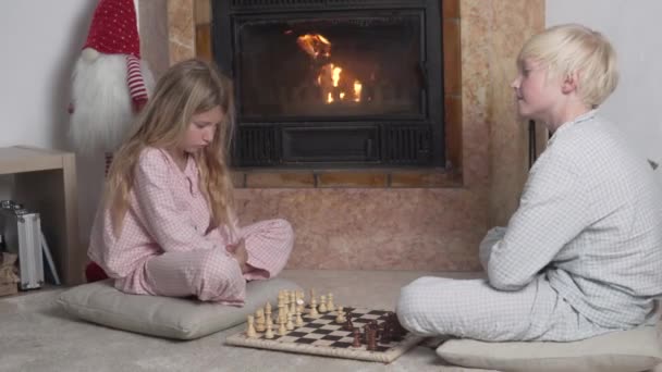 Schöne Jungen Und Mädchen Spielen Schach Kamin Mit Feuer Winter — Stockvideo