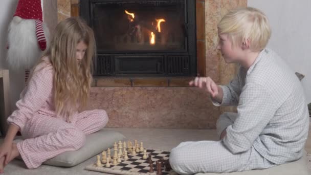 Брат Сестра Играют Шахматы Камина Огнем — стоковое видео