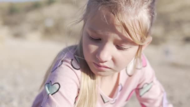 美しい小さな悲しい少女のクローズアップ 大きな青いガラス 鼻に太陽光が当たる — ストック動画