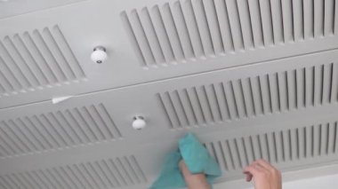 Dikey video, kadın dolabın kapısını tozdan giysilerle siliyor..