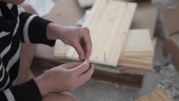 Eine Frau Baut Hause Einen Holzschrank Nach Anleitung Auf Aus — Stockvideo