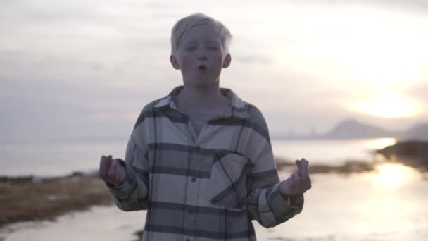 Gdy Młody Chłopiec Medytuje Plaży Zachodzie Słońca Niebo Jest Pomalowane — Wideo stockowe