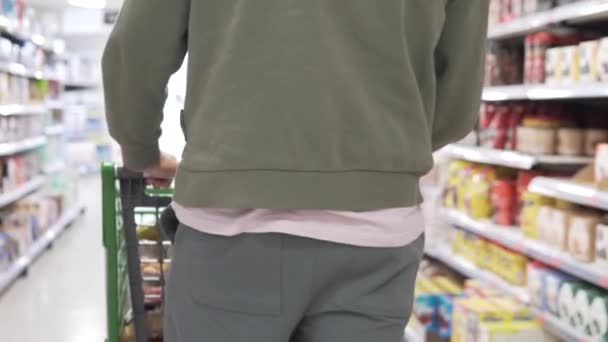2024年4月22日 スペイン アリカンテ メルカドナスーパーマーケット バックビュー スーパーマーケットカウンターの間を歩く食料品カートを持つ男 — ストック動画