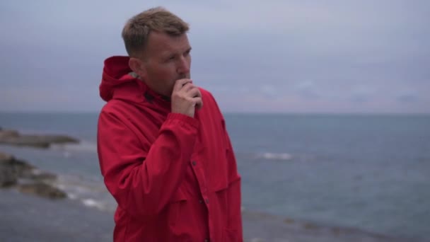 Man Bright Red Jacket Smokes Electronic Cigarette Evening Sea Alone — Stock videók
