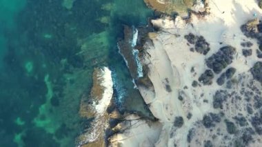 İspanya, Alicante, Cabo de Huertov plajı, yukarıdan manzara, deniz ve kayalık kıyılarda uçan insansız hava aracı, güzel gök mavisi deniz ve uçurumlar.