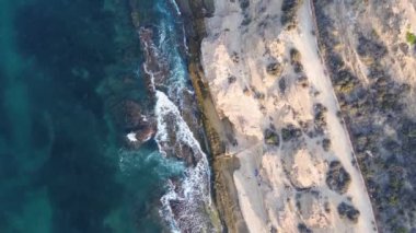 İspanya, Alicante, Cabo de Huertas plajı, İHA saldırısı. İnsansız güzel kayalık bir sahil ve turkuaz Akdeniz