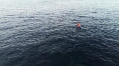 Quadcopter 'dan ateş eden bir aile denizde SUP sürüyor. İspanya, Alicante. Anne ve çocuklar denizde yelken açıyorlar.