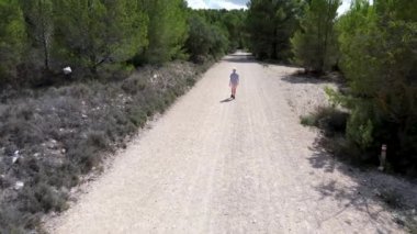 Gökyüzünden drone ateşlendi, sarışın bir çocuk dağ yolunda yürüyor. İspanya 'nın güneyi, yürüyüş.