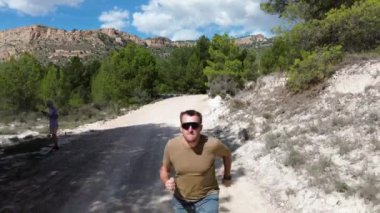 Yazın dağlık yolda koşan esmer adam Bestro, dörtlü kamera görüntüsü..