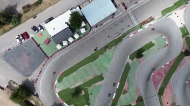 Drone saldırısı, yarış arabaları için pistte karting. Miğferli insanlar yüksek hızlı arabalara binerler. İspanya, Elche