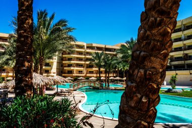 Güneşli bir günde havuzu olan lüks bir otel. 