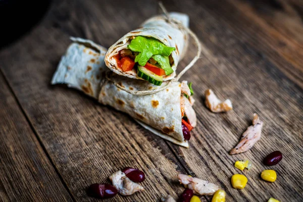 stock image Traditional mexican tortilla wrap with chicken meat and vegetables on wood table