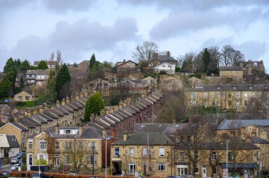 Büyüleyici bir yerleşim yeri bulutlu hava koşulları altında bir tepe üzerindeki teraslı evleri yakalıyor ve İngiltere 'nin Batley, Batı Yorkshire kasabasını yaratıyor..