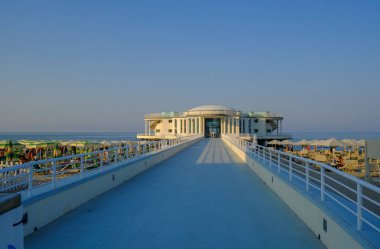 Gün batımında gökyüzünde ve plajda güneş şemsiyeleri ile Rotonda al mare, İtalya Senigallia 'da uzun yol