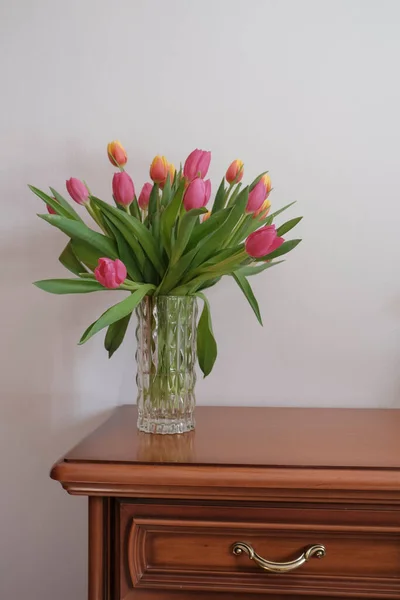 花瓶里的一束粉红色和黄色的郁金香 在木制抽屉里的白色上紧密地交织在一起 内部细节 酒店内部 — 图库照片