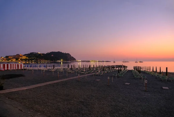 海と地平線の上に黄色のサンベッドとホテルと丘のビーチで日没 Sestri Levante リグーリア州 イタリア — ストック写真