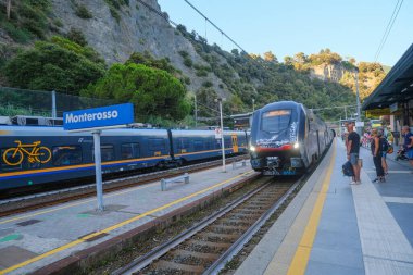 Haziran 2023 Monterosso, İtalya: Monterosso 'daki istasyona gelen bölgesel tren yolcuları ve dağları aşıyor. 