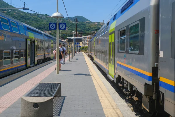 stock image June 2023 La Spezia, Italy: Railway station, passengers with suitcases and fast trains across the mountains landscape 