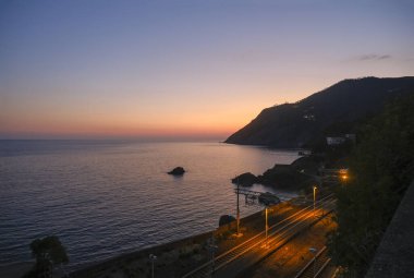 Framura tren istasyonunun ve Framura sahilinin günbatımı deniz manzarası ve dağların üzerindeki hava manzarası.