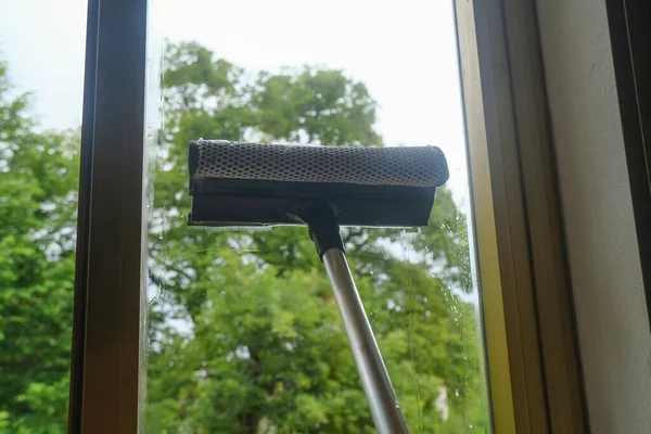 cleaning the window with a window cleaning mop closeup. Cleaning services