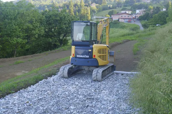 Ağustos 2023 Parma, İtalya: Sarı ve siyah Komatsu kazıcısı karayolu yapımında. Ağır makineler