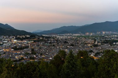 Lijiang Eski Şehir kuş bakışı. Yerel tarihi mimari ile Alacakaranlık vaktinde çatı binası.