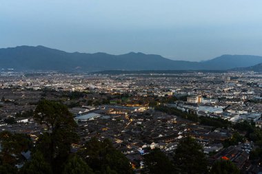 Lijiang Eski Şehir kuş bakışı. Yerel tarihi mimari ile Alacakaranlık vaktinde çatı binası.