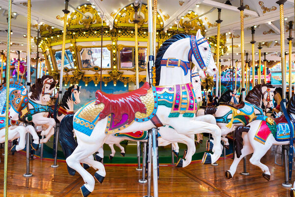 Carousel in amusement park. Horses on a traditional fairground vintage carousel.