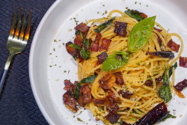 Kurutulmuş acılı spagetti ve kızarmış domuz pastırması.