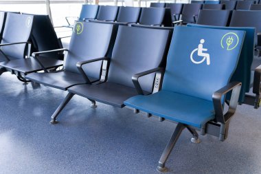 Kamu bekleme alanındaki boş mavi koltuklar fiziksel engelliler ve özel ihtiyaçları olanlar için.