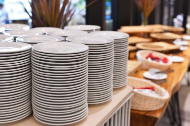 Restoranda bir sürü beyaz tabak üst üste dizilmiş.