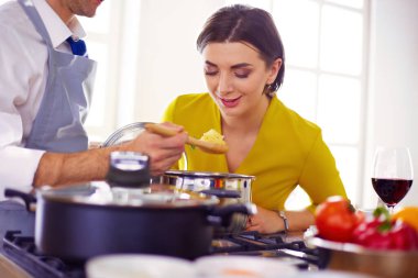 Evdeki mutfakta birlikte yemek pişiren çift..