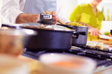 Evdeki mutfakta birlikte yemek pişiren çift..